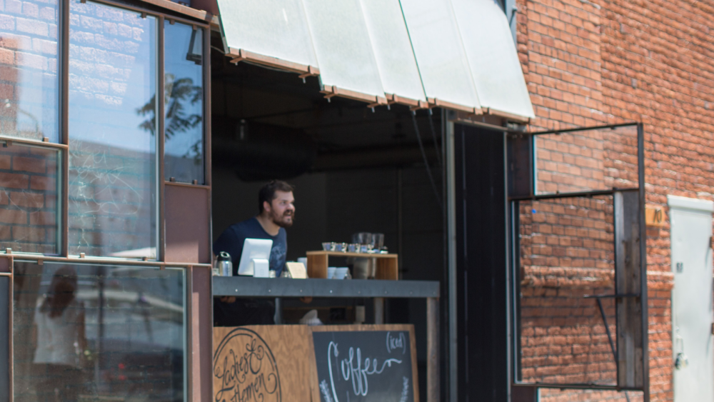 A worker at a coffee shop waiting to take orders