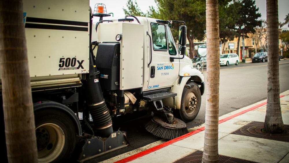 street sweeping vehicle near sidewalk