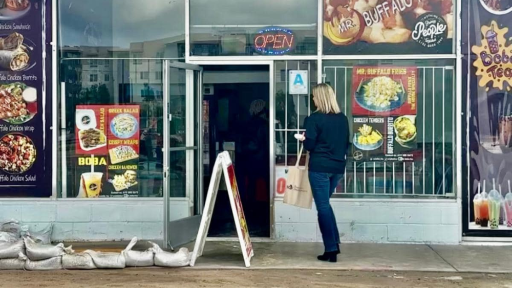 person walking into a business to share information on storm recovery resources