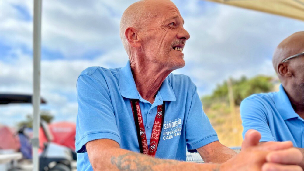 picture of man in blue shirt and red lanyard 