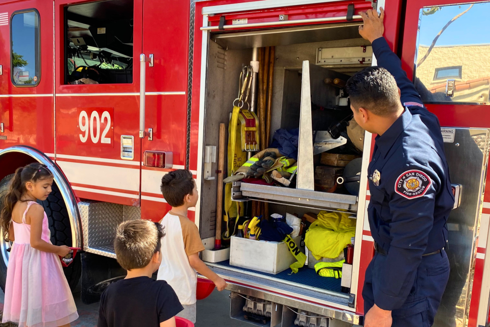 Firefighter and children viewing a fire truck