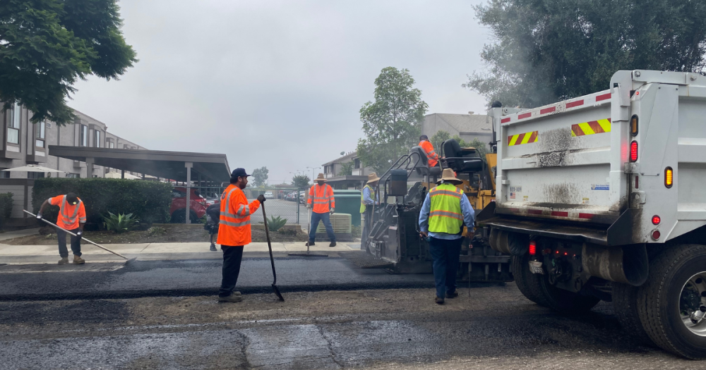 five transportation team members working on resurfacing road