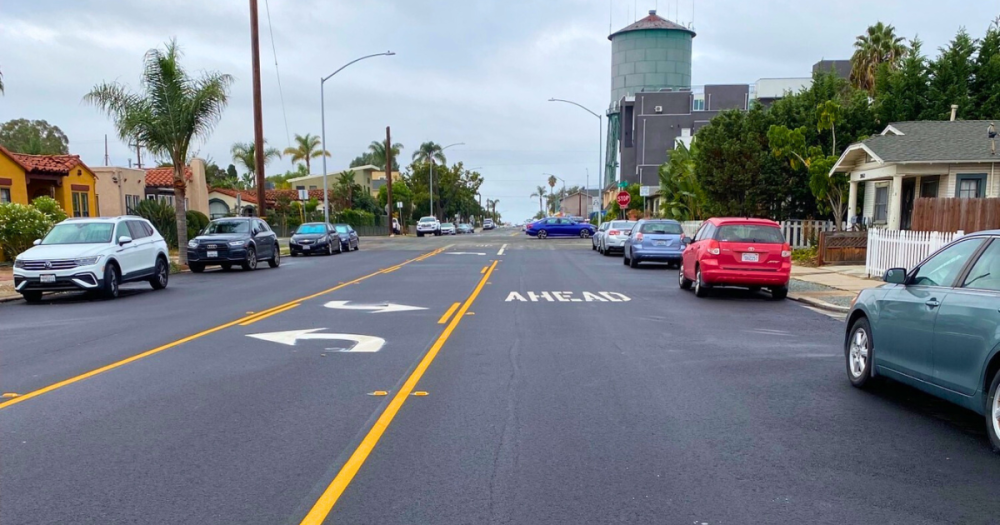 Newly slurry sealed road surrounded by parked cars