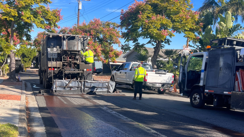 street crews working on a vehicle to slurry seal a road in san diego