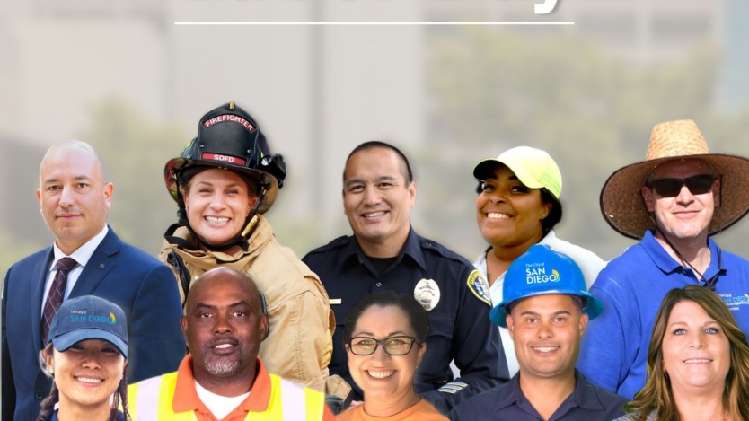 two rows of employees from various positions smiling in front of the city administration building