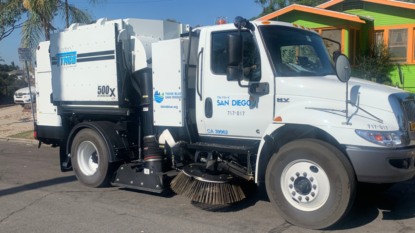 street sweeping truck in front of a house.