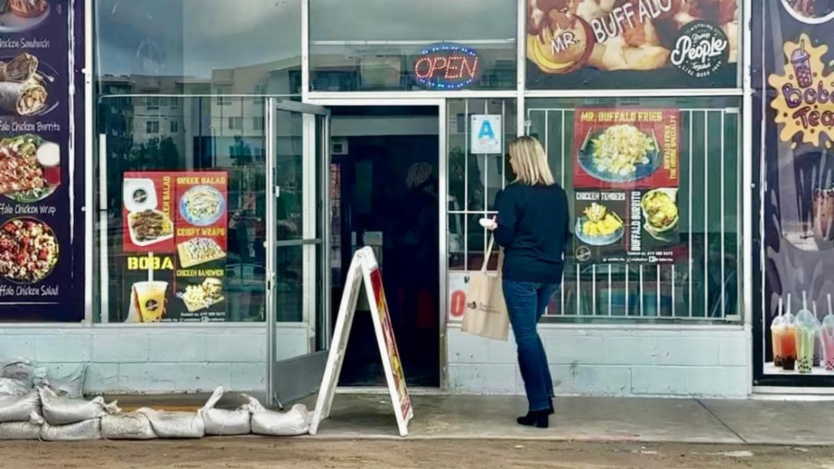 person walking into a business to share information on storm recovery resources