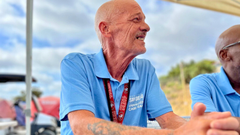 picture of man in blue shirt and red lanyard 