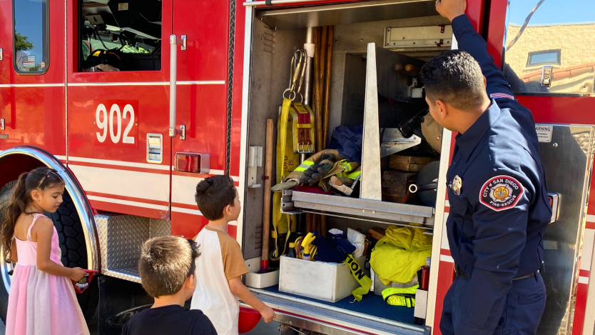 Firefighter and children viewing a fire truck